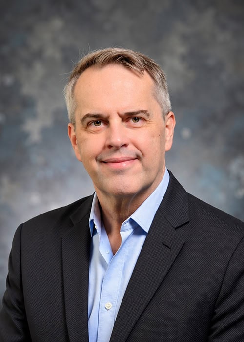 William Beem, IAM program leader, smiling in a dark suit and light blue shirt